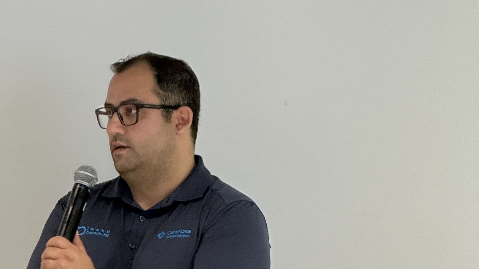 Hossein Aghasharif of CertNova answering a question with a microphone in hand